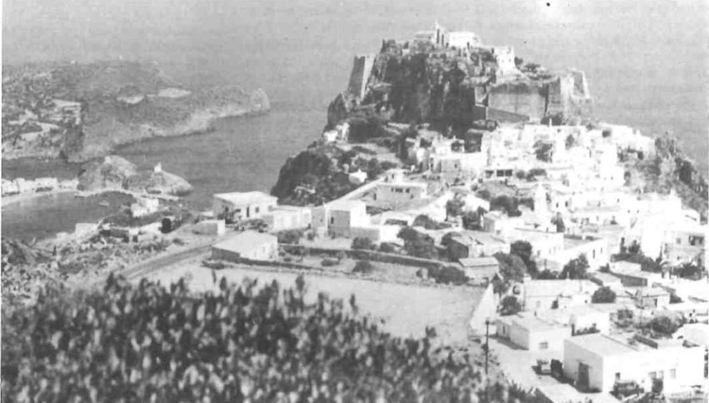 Although Xenia came from Russia and Serge belonged to the wandering cities of Asia, Kythera entered the family as a mythic counter-melody.
It was the island invoked in stories, the island of olive trees and white stucco houses, of stone paths, blue shutters, church bells, goat tracks, sea wind and terraces silvered with leaves. It was older than any quarrel. Older than surnames. Older than abandonment.
In classical painting and literature, Kythera was never only an island. It was a destination of desire.
Watteau painted lovers embarking for Cythera beneath a rose-gold sky, satin gowns billowing like phrases in a minuet. The figures seem to be arriving and departing at once, caught in the suspended rhythm between longing and loss. Aphrodite hovers over the island as an idea rather than a woman: love born from sea-foam, beauty rising from violence, tenderness emerging from rupture.
That was the secret Kythera carried into the novella.